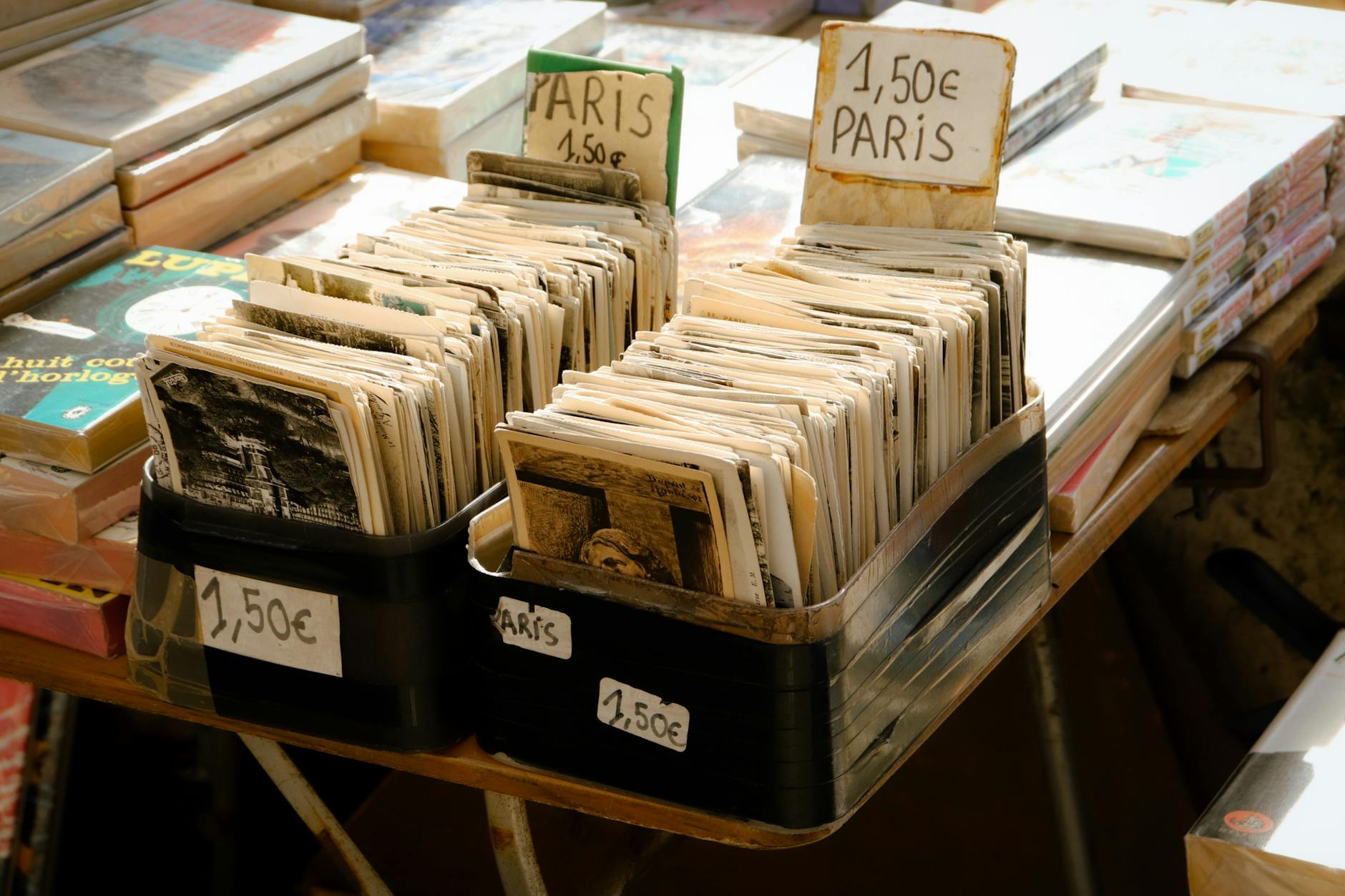 Collection of vintage postcards for sale at a Paris market stall, with focus on retro charm.