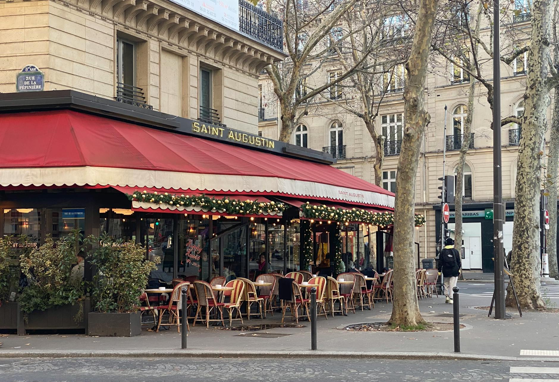 Cozy outdoor seating at a Parisian café with festive decorations.