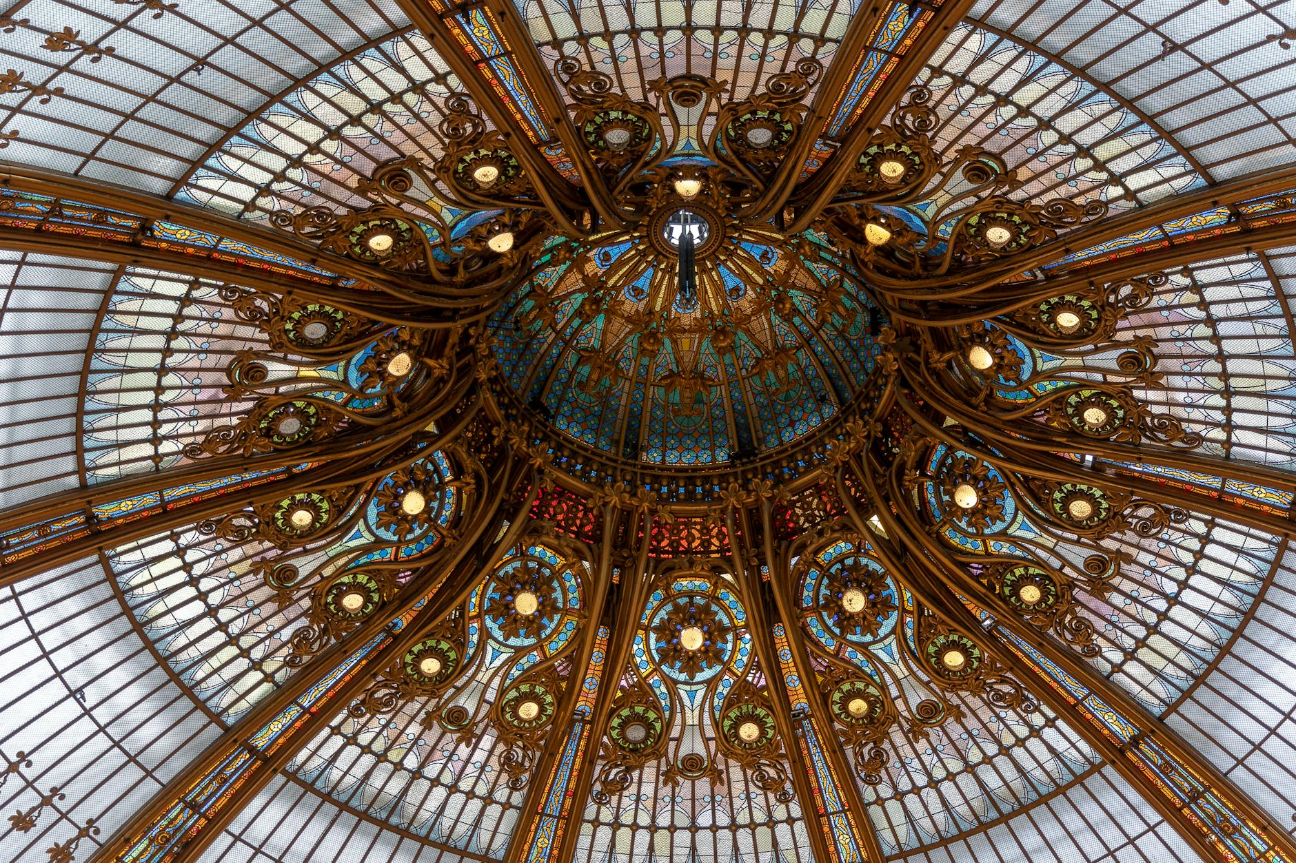 A stunning view of a richly decorated glass dome ceiling in Paris, France.