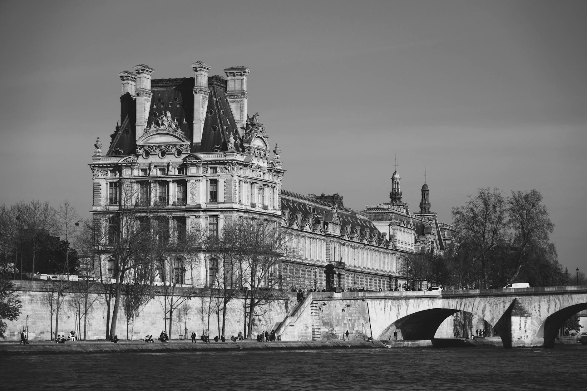 Elegant architecture of Paris captured beside the Seine River in a classic black and white tone.