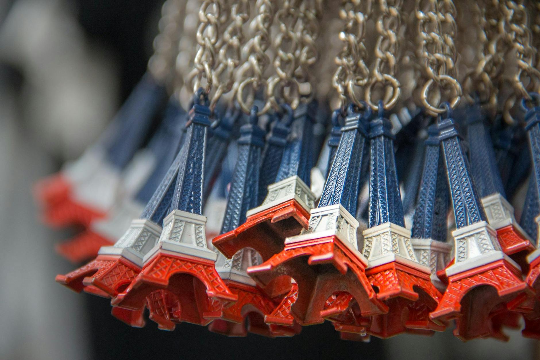 Close-up of Eiffel Tower souvenir keychains in Paris, France, emphasizing abundance and vibrant colors.