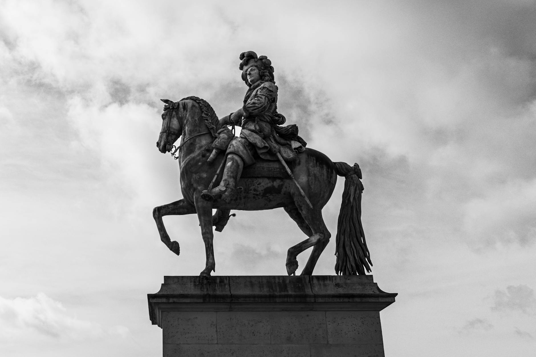 Black and white image of the equestrian statue of Louis XIV in Paris.