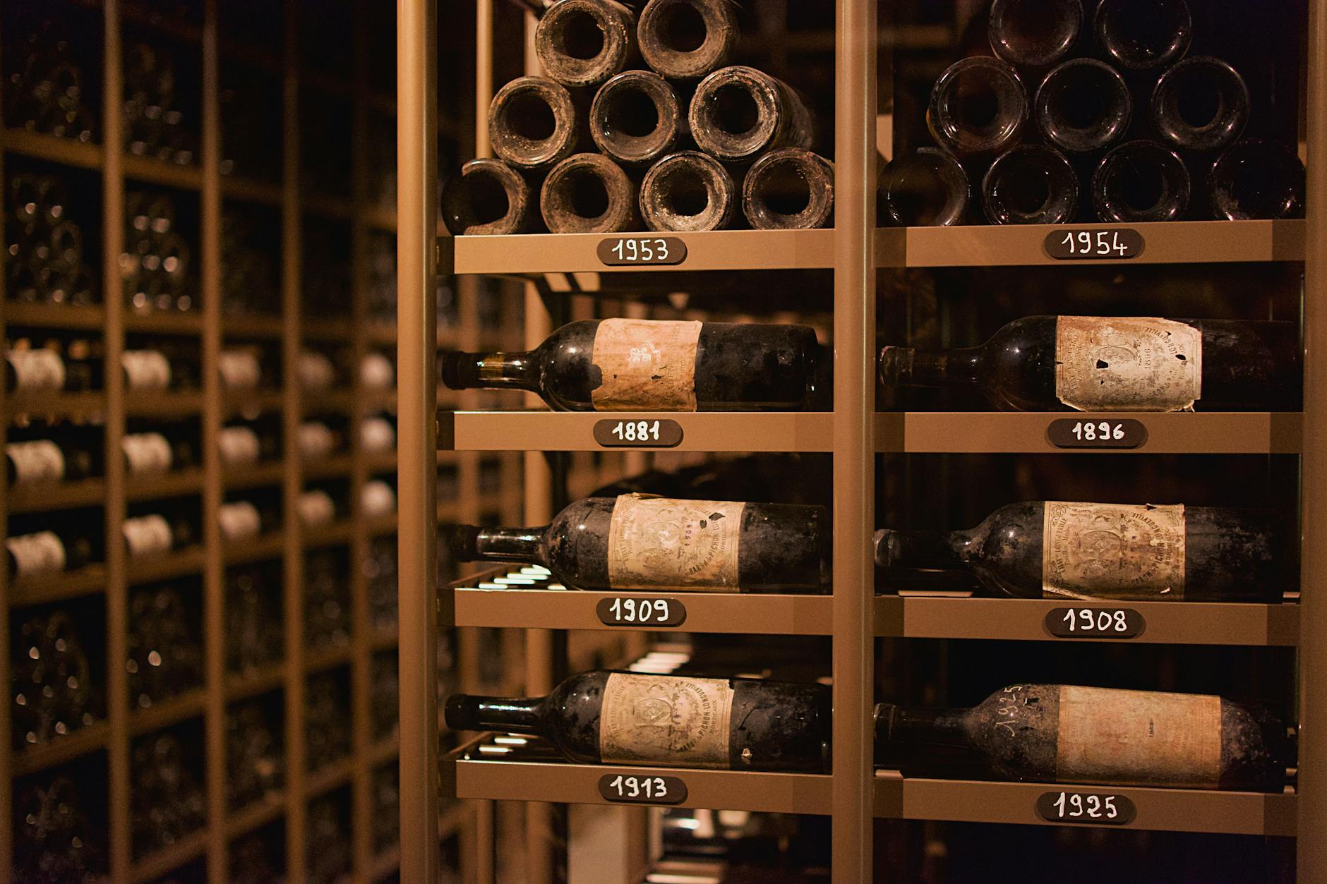 Sommelier leading private wine tasting in historic Paris cave cellar with stone vaults and wine bottles