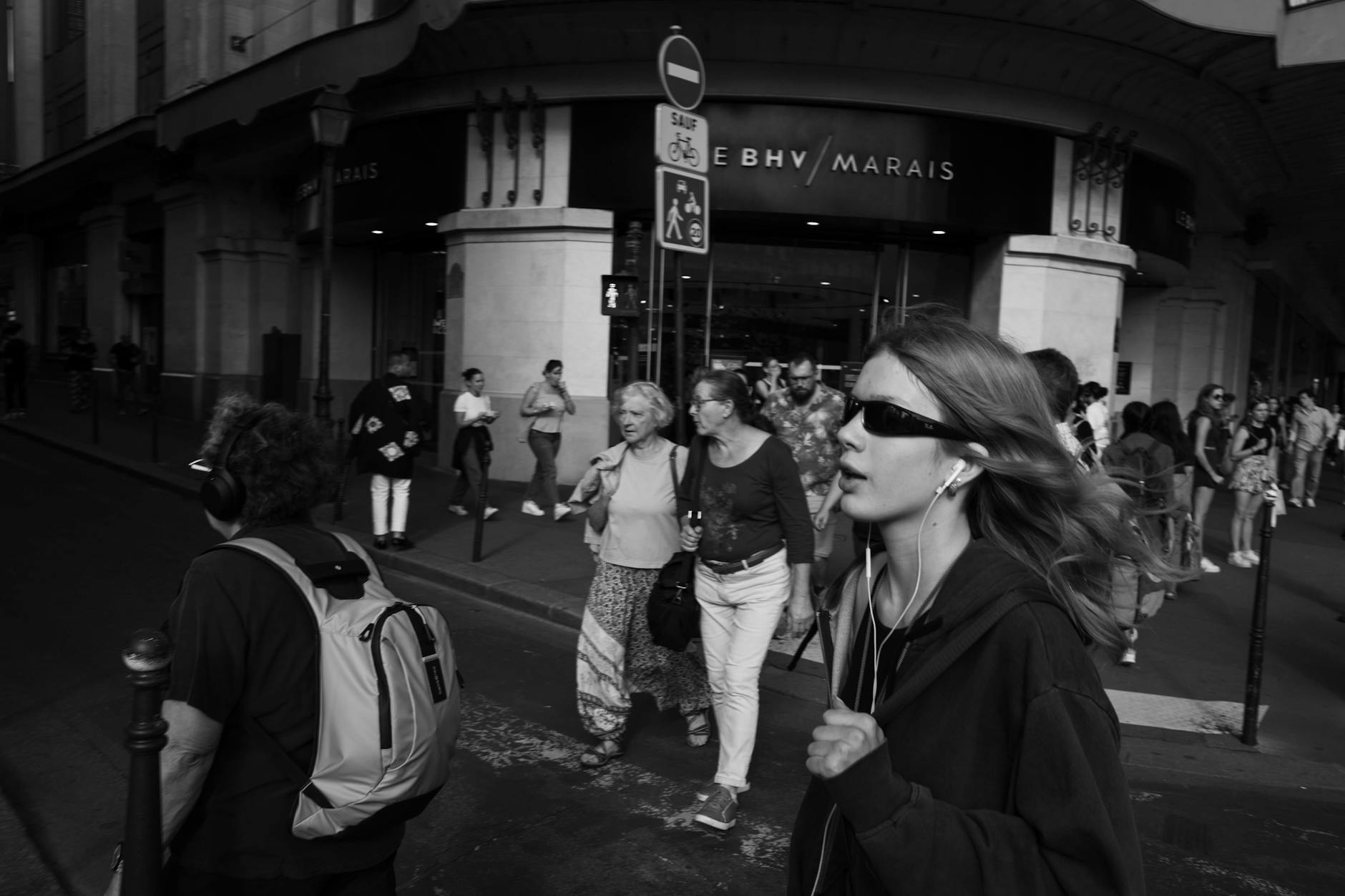 A bustling city street scene in black and white with diverse pedestrians.