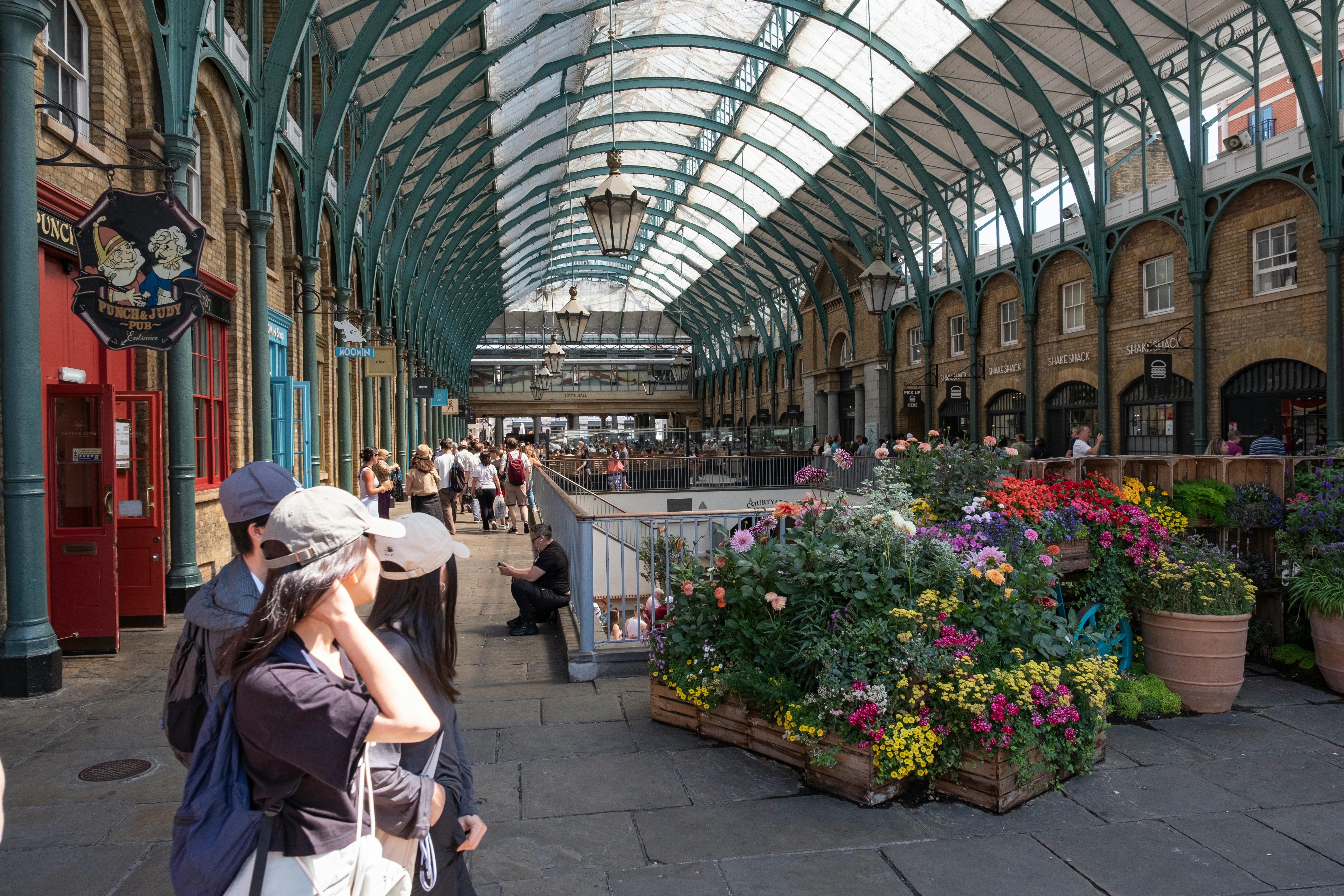 Ivy-lined outdoor stalls at upscale Paul Bert Serpette market in Saint-Ouen, showcasing luxury antiques and vintage treasures