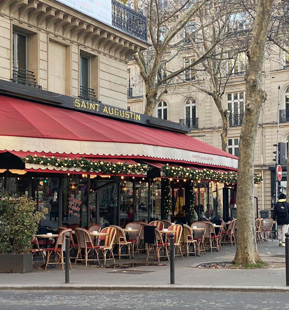 Cozy outdoor seating at a Parisian café with festive decorations.