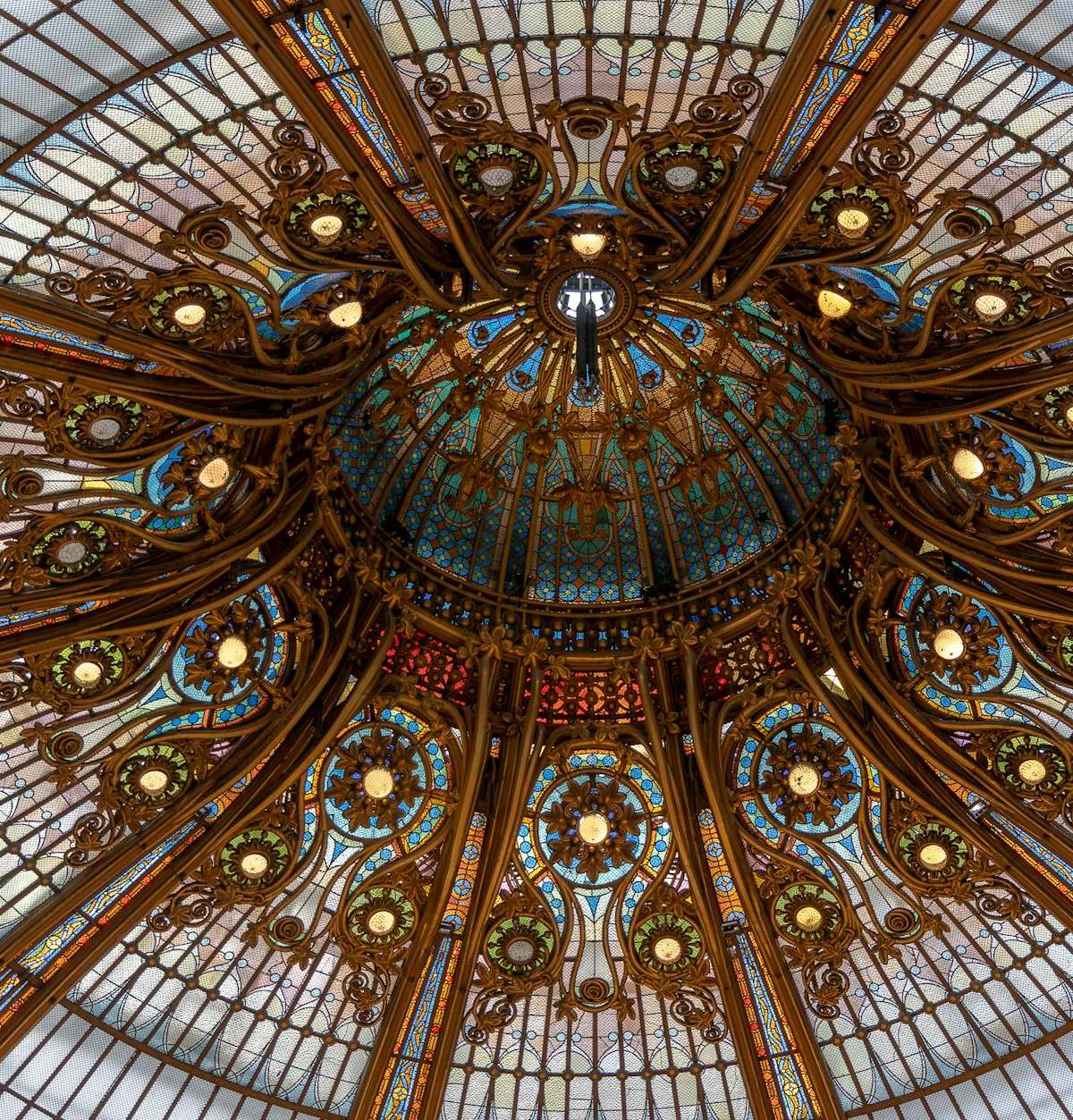A stunning view of a richly decorated glass dome ceiling in Paris, France.