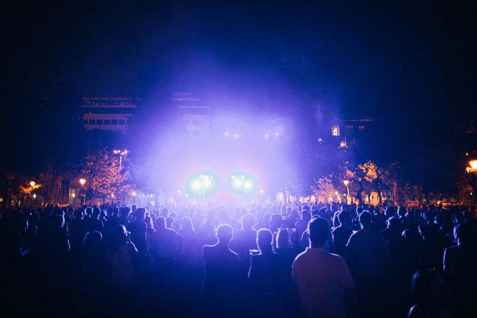 A lively outdoor night concert with colorful lights and a large crowd during the Fête de la Musique in Paris