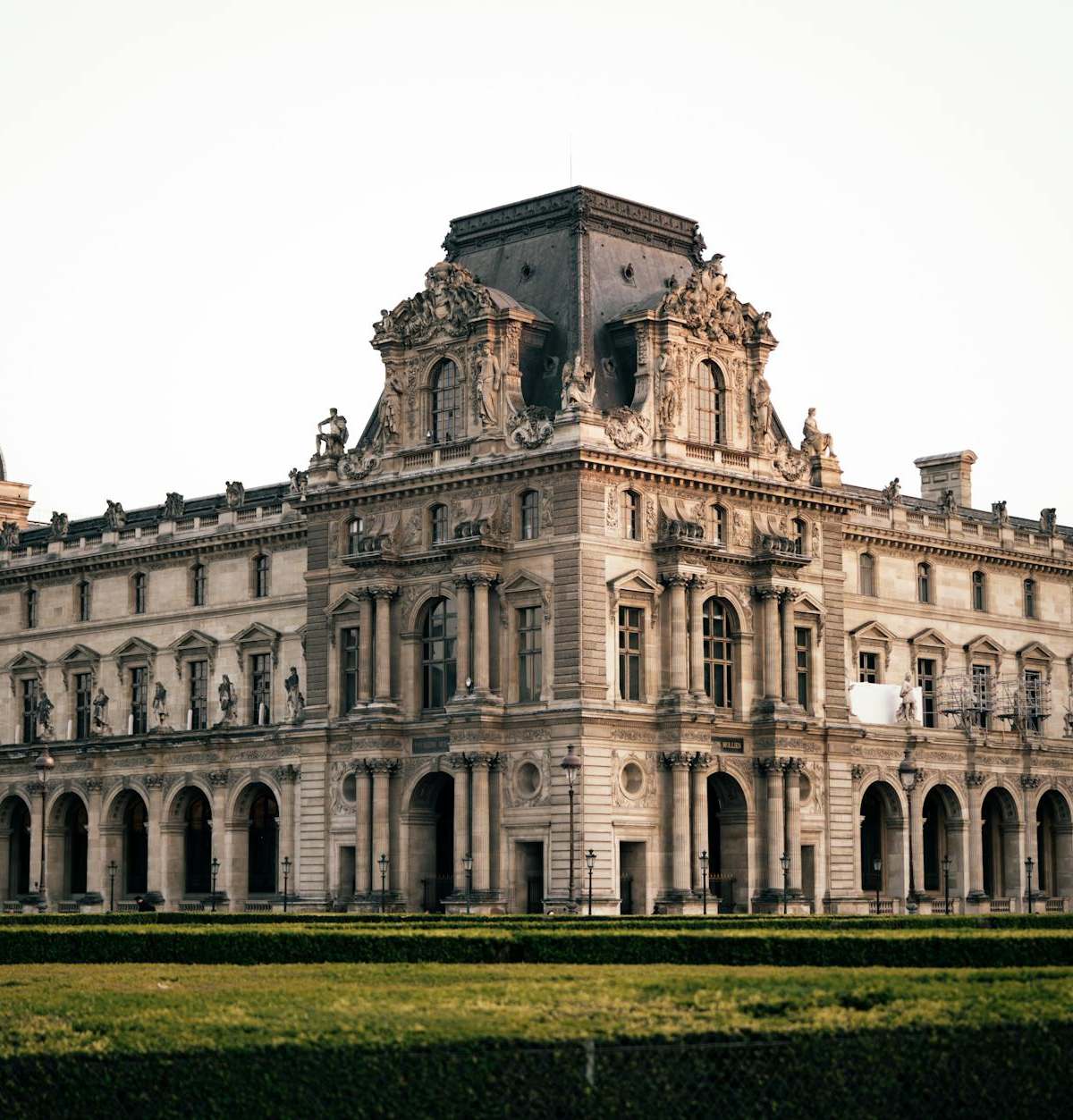 Elegant view of the historic Louvre Museum in Paris, showcasing its grand architecture at dusk.