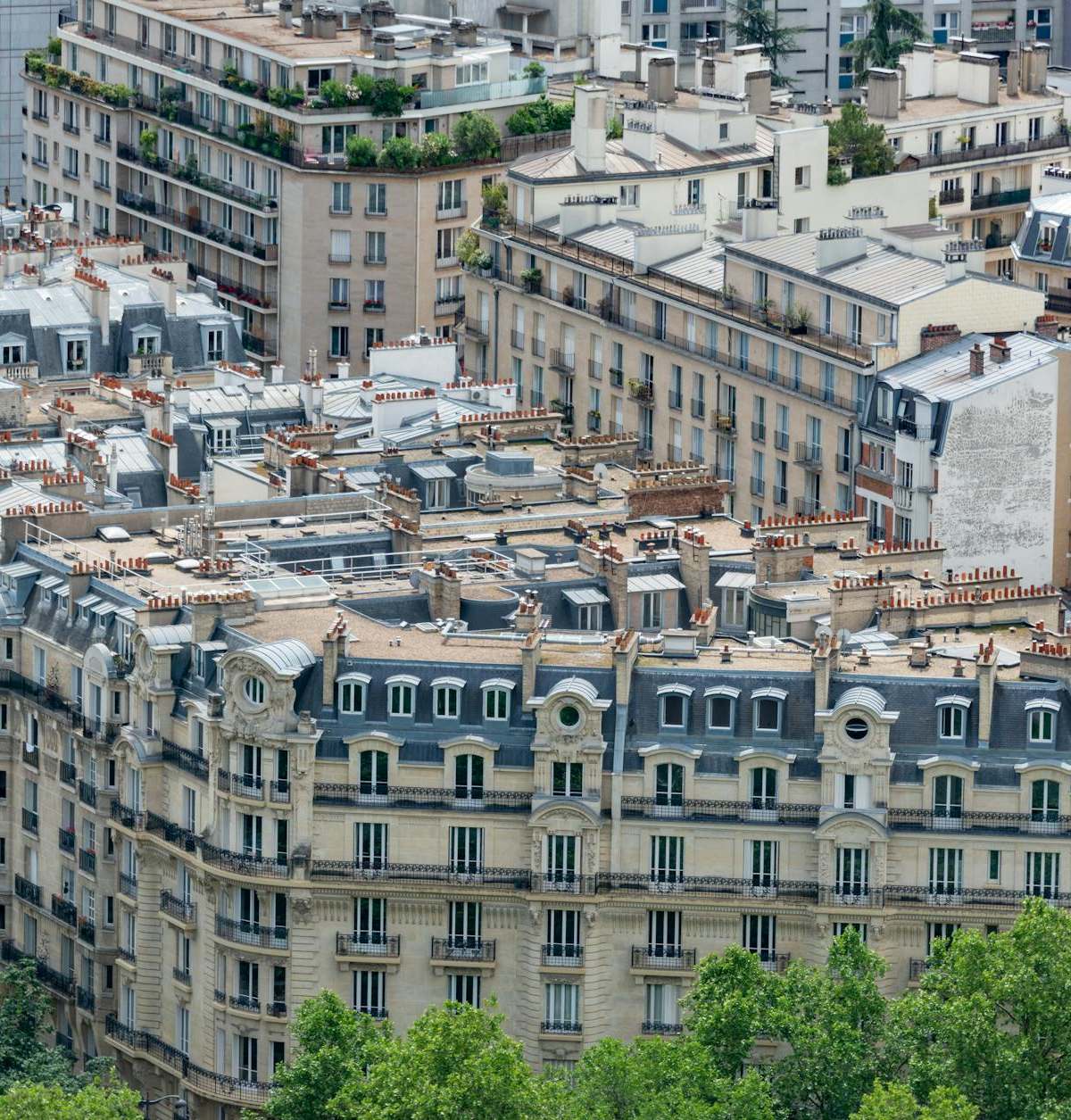 Discover the classic Haussmannian architectural style of Parisian rooftops and facades from a high angle view.