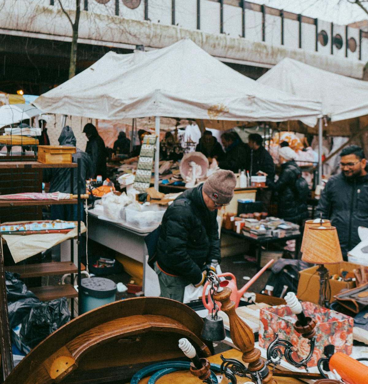 Vibrant scene of Marché des Enfants Rouges market stalls with fresh produce, food counters, and locals in Paris's Marais d...