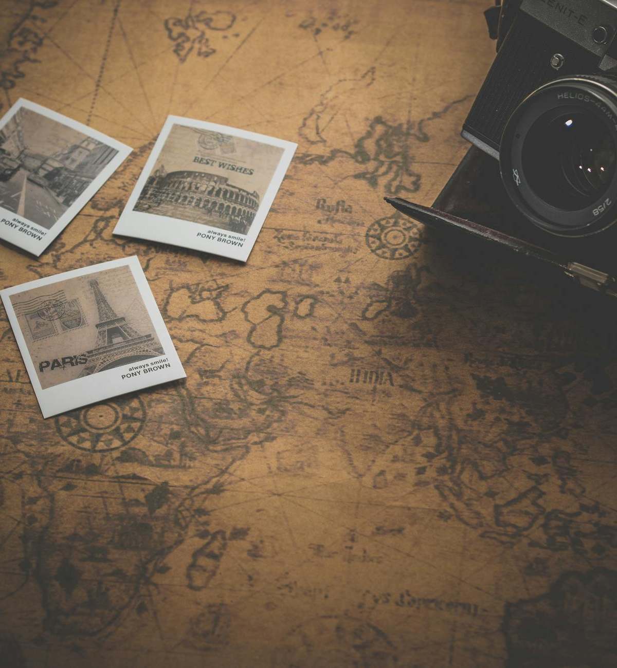 Vintage style still life with a camera, map, and travel photos. Perfect for travel enthusiasts.