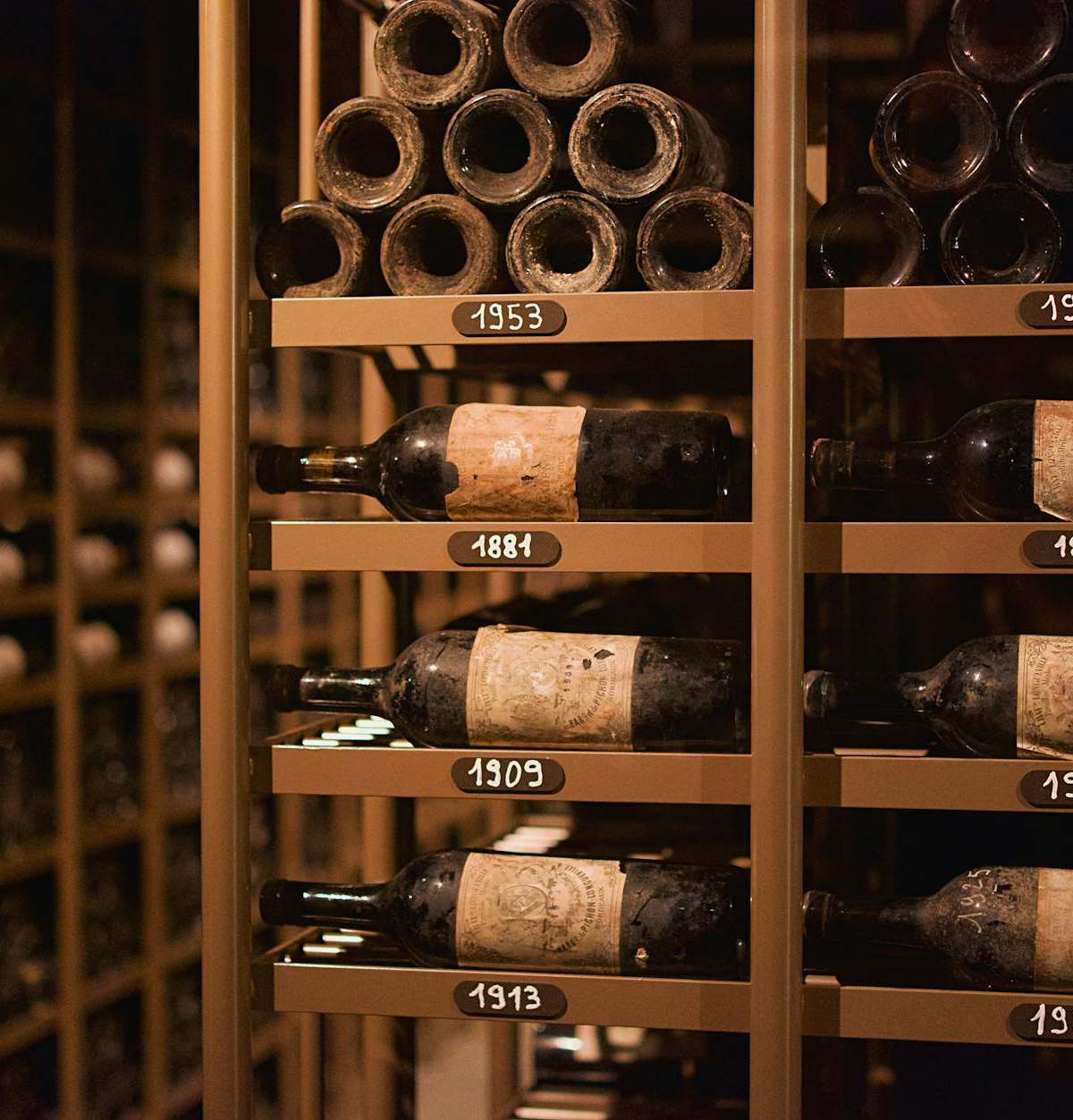 Sommelier leading private wine tasting in historic Paris cave cellar with stone vaults and wine bottles