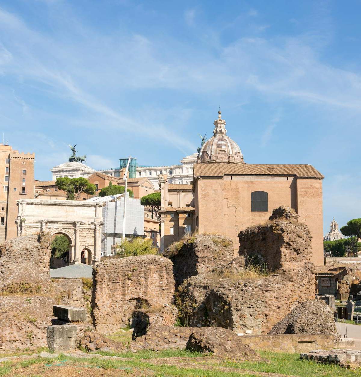 Explore the historic ruins of Rome under a clear blue sky.