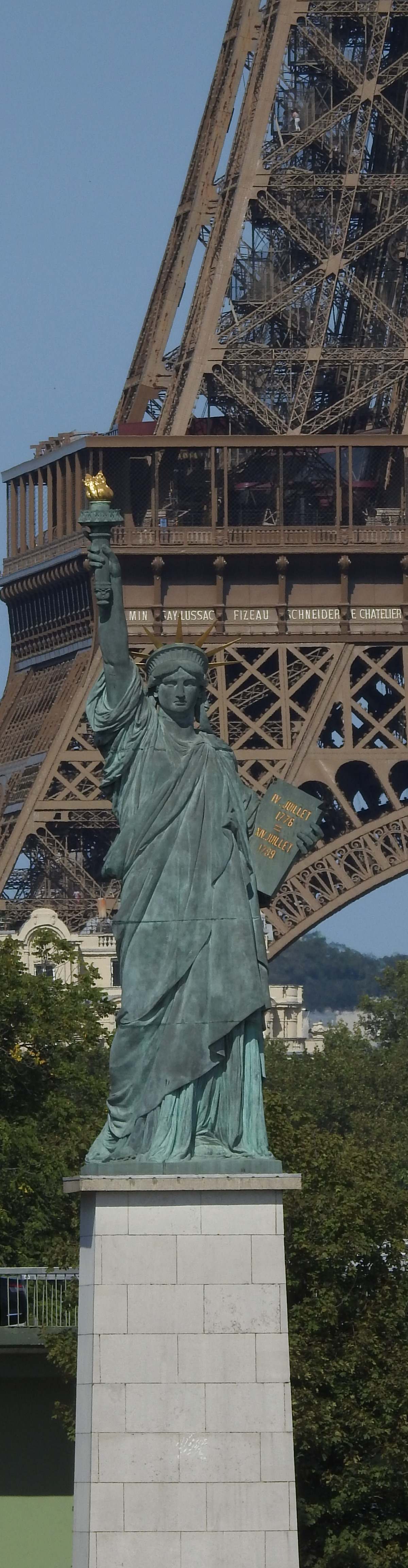 Statue of Liberty replica on Île aux Cygnes island in Paris with Seine river and Eiffel Tower in background