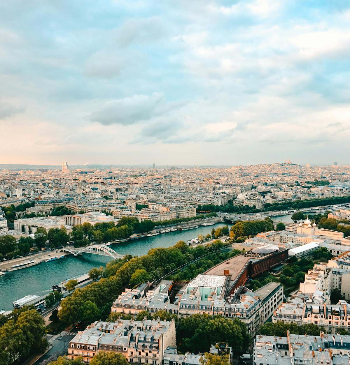 A stunning aerial view of Paris, showcasing the Seine River and iconic landmarks during sunset.