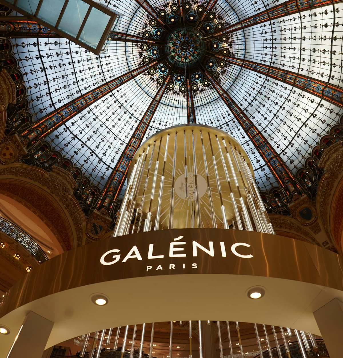 Ornate interior dome of Galeries Lafayette in Paris, showcasing luxury and architectural beauty.