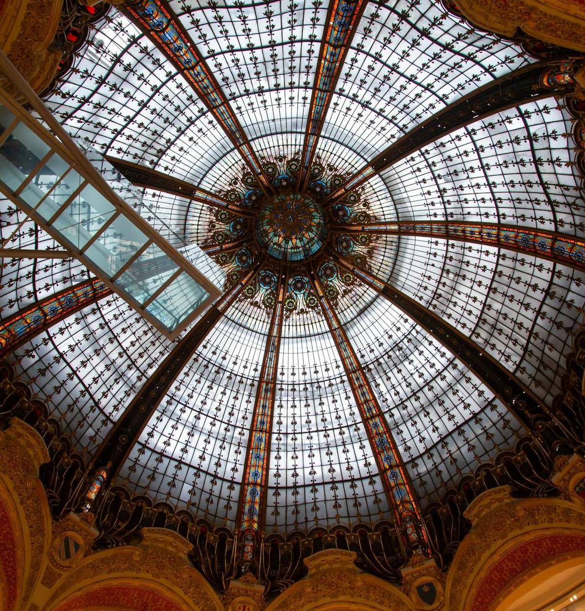 Ornate stained glass dome inside Galeries Lafayette, Paris.