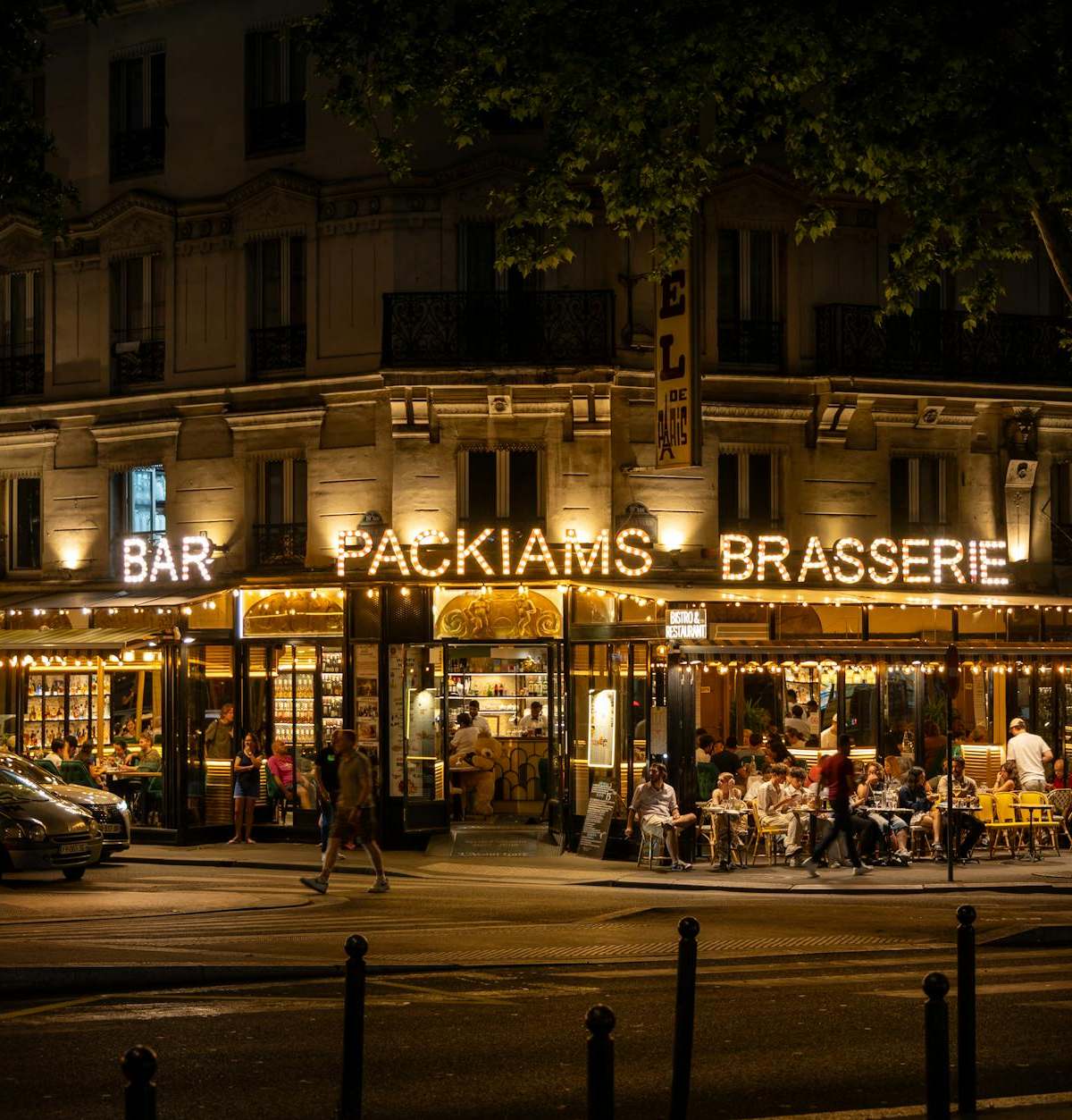 Packiams Brasserie lively evening scene in Paris, showcasing outdoor dining and vibrant nightlife.