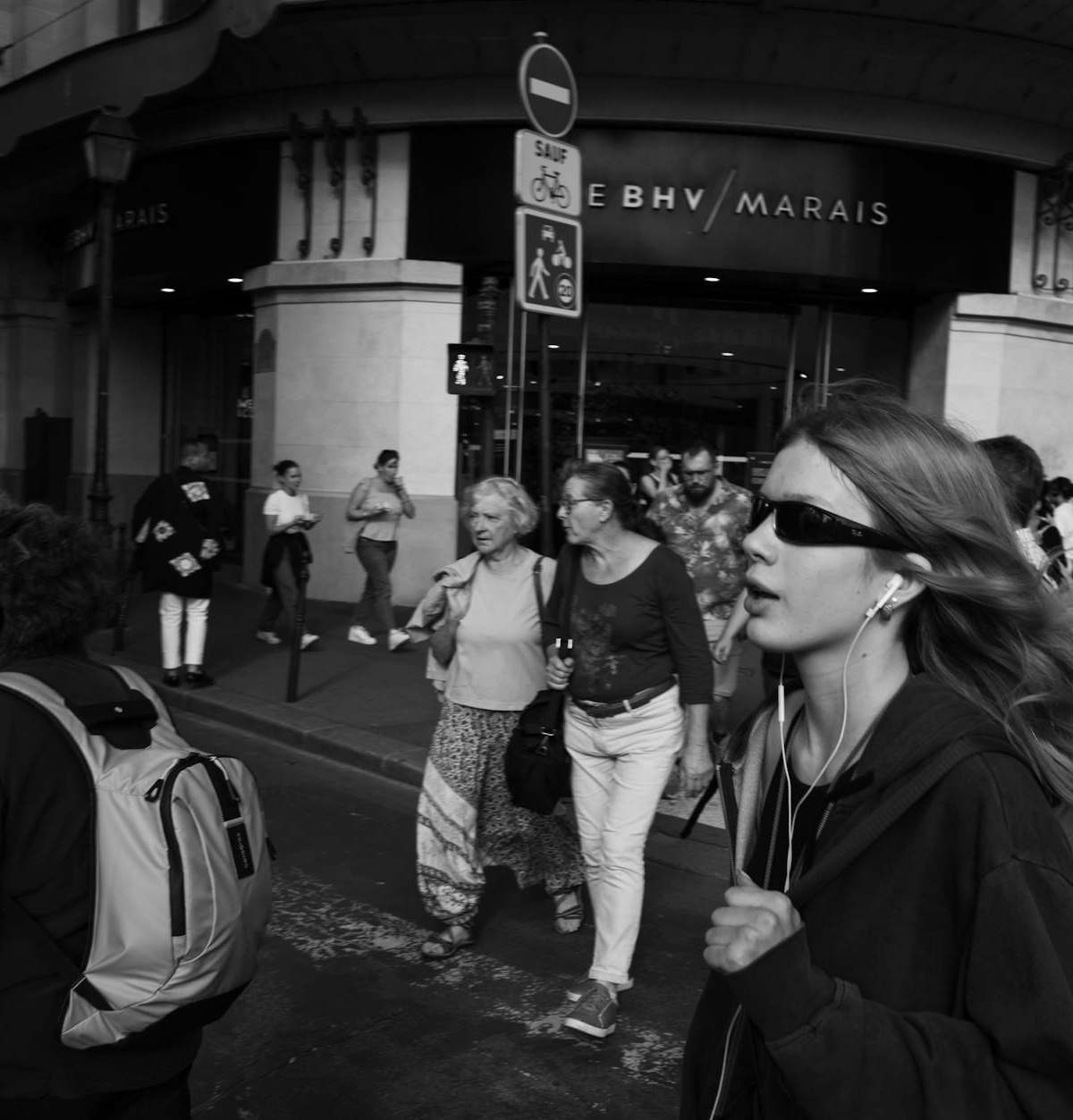 A bustling city street scene in black and white with diverse pedestrians.