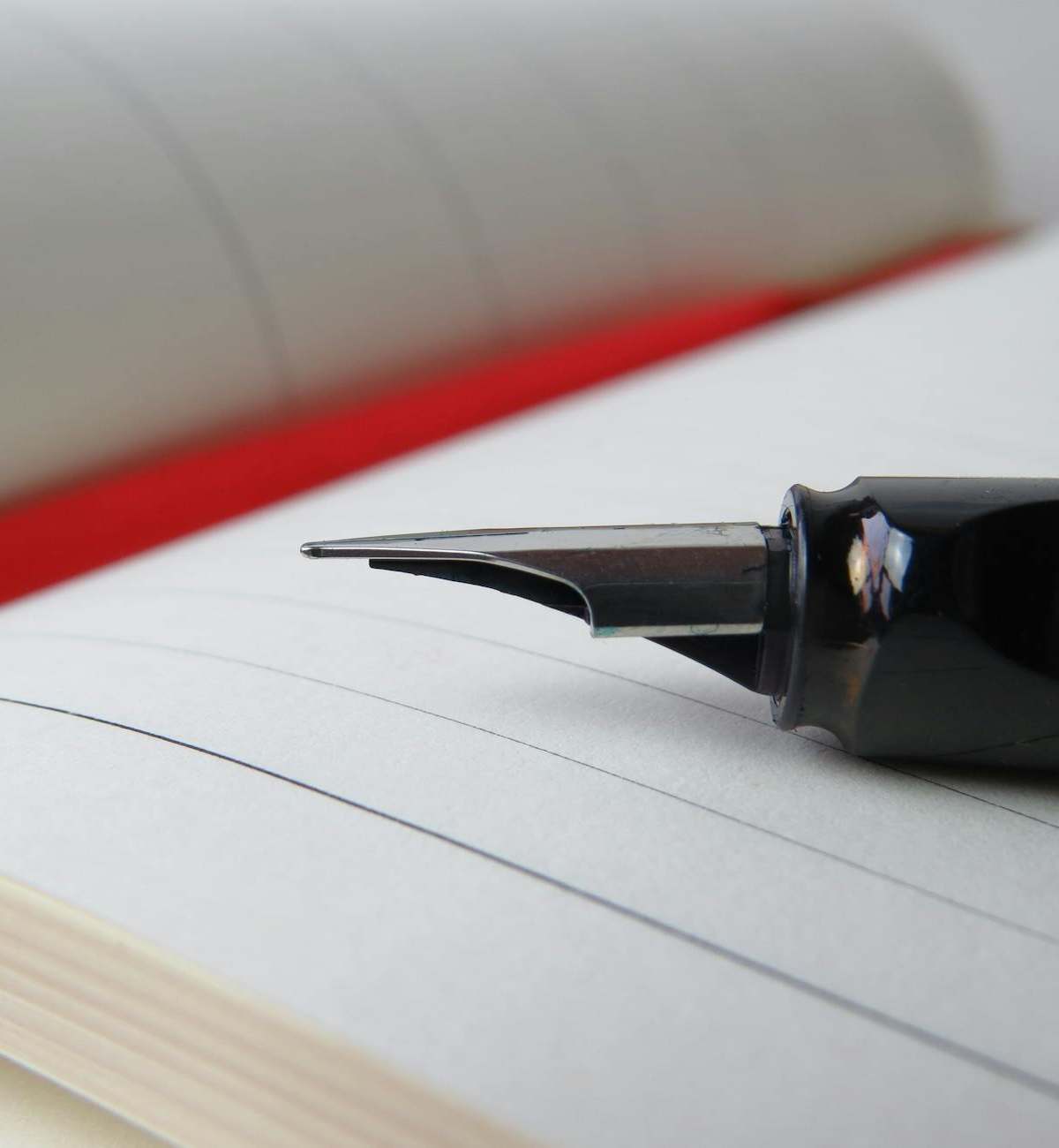 Fountain pen rests on an open lined notebook, symbolizing writing and creativity.