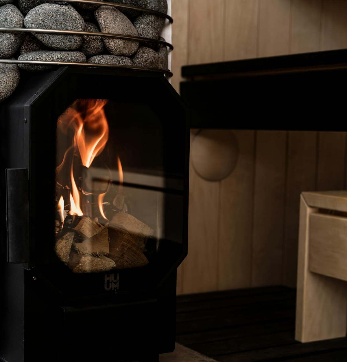 Wood-fired sauna with stone heater exemplifying Nordic design and relaxation.