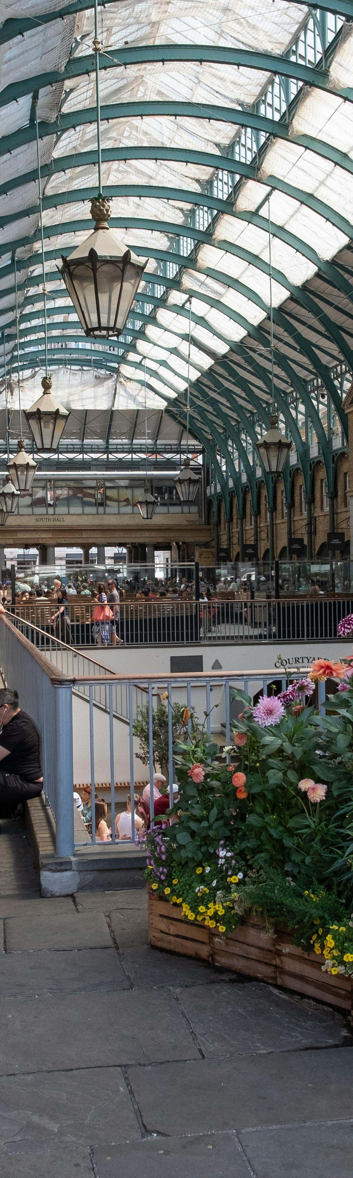 Ivy-lined outdoor stalls at upscale Paul Bert Serpette market in Saint-Ouen, showcasing luxury antiques and vintage treasures