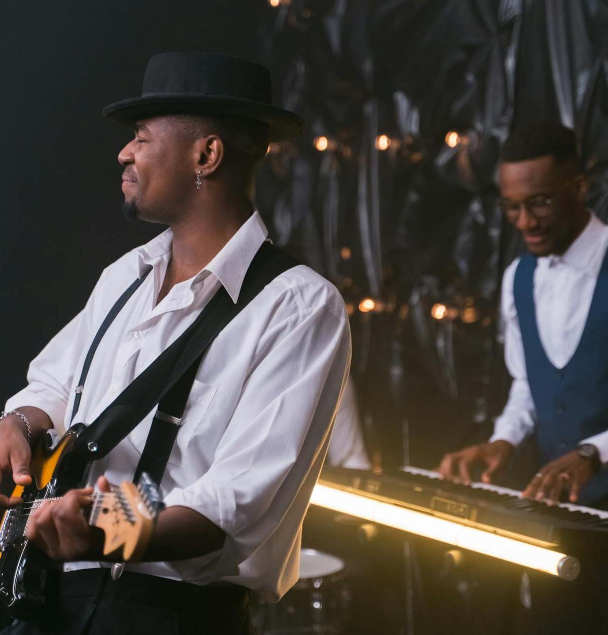 Energetic performance by jazz musicians with guitar and piano, creating soulful entertainment.