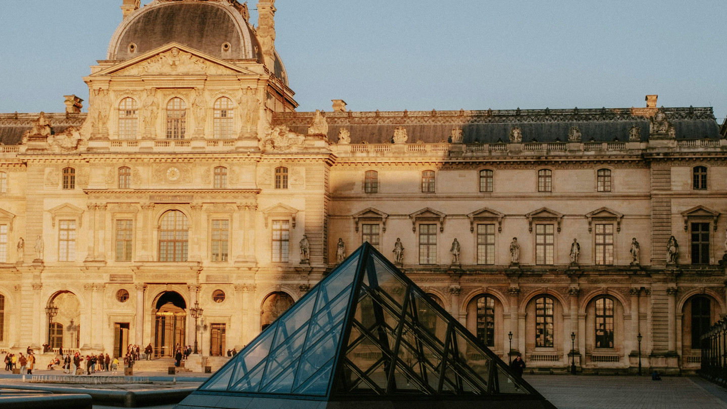 Stunning view of the Louvre Museum with its iconic glass pyramid in Paris, France